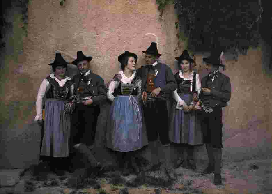 A Tyrolean singing troupe in traditional costume meets by a medieval wall, Innsbruck, Austria, published 1932 
