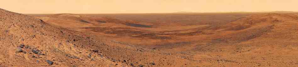 The View Of Basin To The Northeast Of Husband Hill On MarsThis view of Mars was captured by the Spirit rover, which has been roaming Mars and sending back photos and data samples since 2004. In this shot, basaltic plains stretch to the distant rim of Thira Crater. Mosaic compiled of multiple images. Spirit Rover, Nov. 3, 2005.