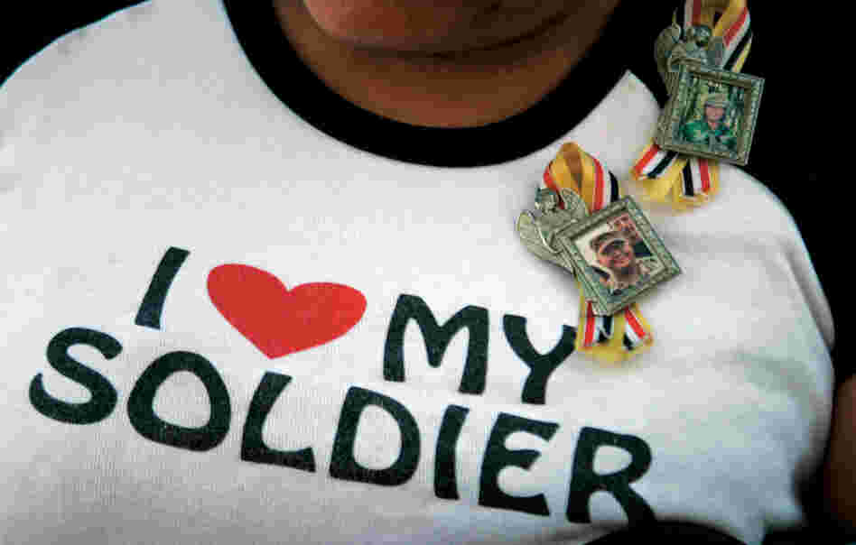 A woman shows her allegiance to both her active duty son and returned veteran husband, who just returned from a year long deployment to Iraq. A homecoming parade was held in Rio Ranch, N.M. on Sunday, Nov. 19, 2006.
