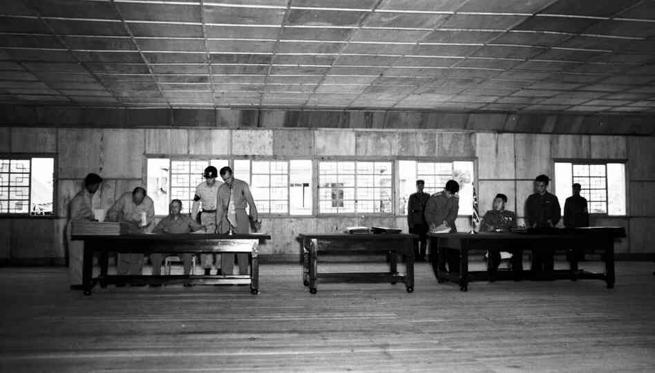Gen. William K. Harrison, Jr., seated at left, and North Korean Gen. Nam Il, seated at right, sign armistice documents in Armistice Hall in Panmunjom, a no man's land between the Koreas, on July 26, 1953. 