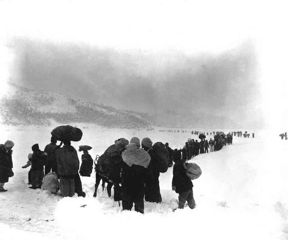 A seemingly endless file of Korean refugees slogs through snow outside Kangnung in January 1951. 