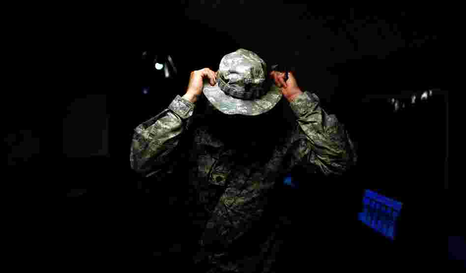 Army Lt. Col. Johnny Davis of the 101st Airborne Division puts on his boonie hat while talking to his men at a combat outpost in the Zhari district of Kandahar province, a Taliban stronghold in southern Afghanistan. Davis commands the division's 1st Battalion, 502nd Infantry Regiment, 2nd Brigade Combat Team, which is situated near Sangeray, capital of Zhari district.
