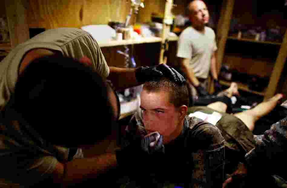 Pvt. Dan Oswald with Alpha Company is cared for by medics in an aid station after being hit by shrapnel from a hand grenade thrown over a wall at his patrol. Oswald suffered only minor wounds to his leg and face and was expected to return to his unit right away.
