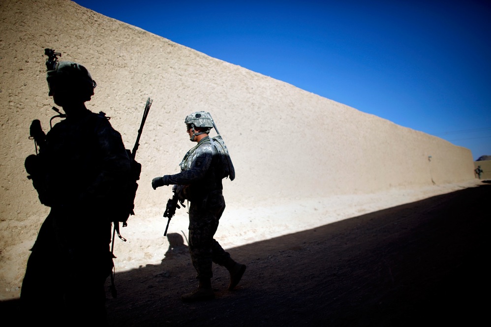Soldiers from Alpha Company walk beneath the high mud walls that make up the labyrinth of alleyways and corridors of the village of Sangeray. In less than a week, five grenade attacks injured more than a half dozen U.S. and Afghan troops.