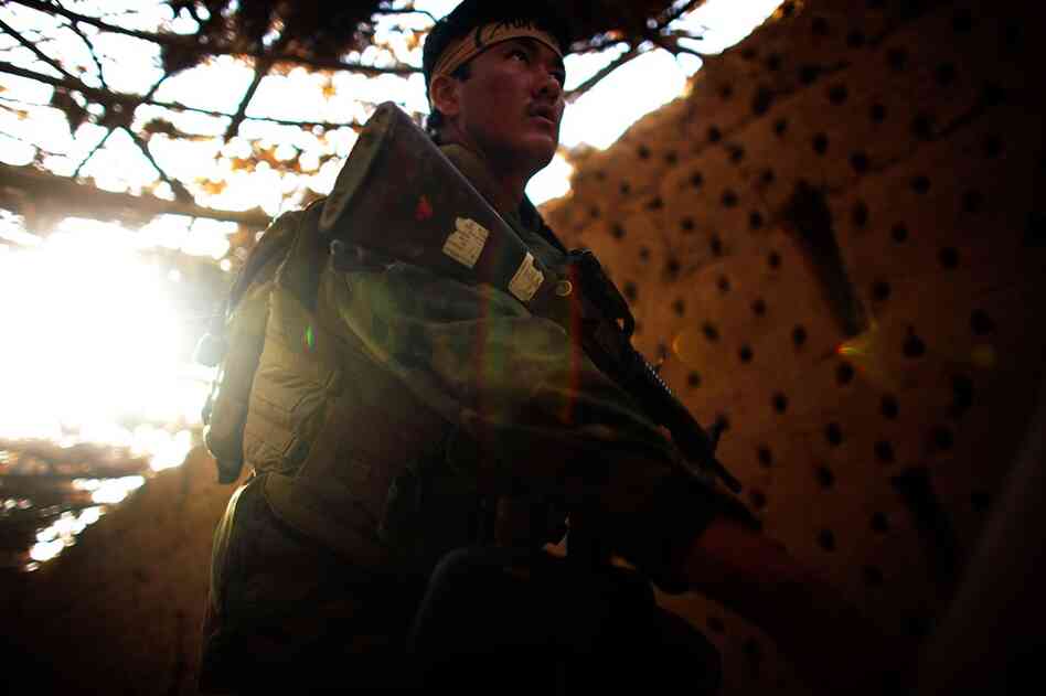 An Afghan National Army soldier walks past a grape-drying barn while looking for sniper hideouts. Buildings in the area are routinely trapped with explosives to be triggered by soldiers. The top Taliban leader, Mullah Omar, was born in the Zhari area, and many of his first recruits came from this region.