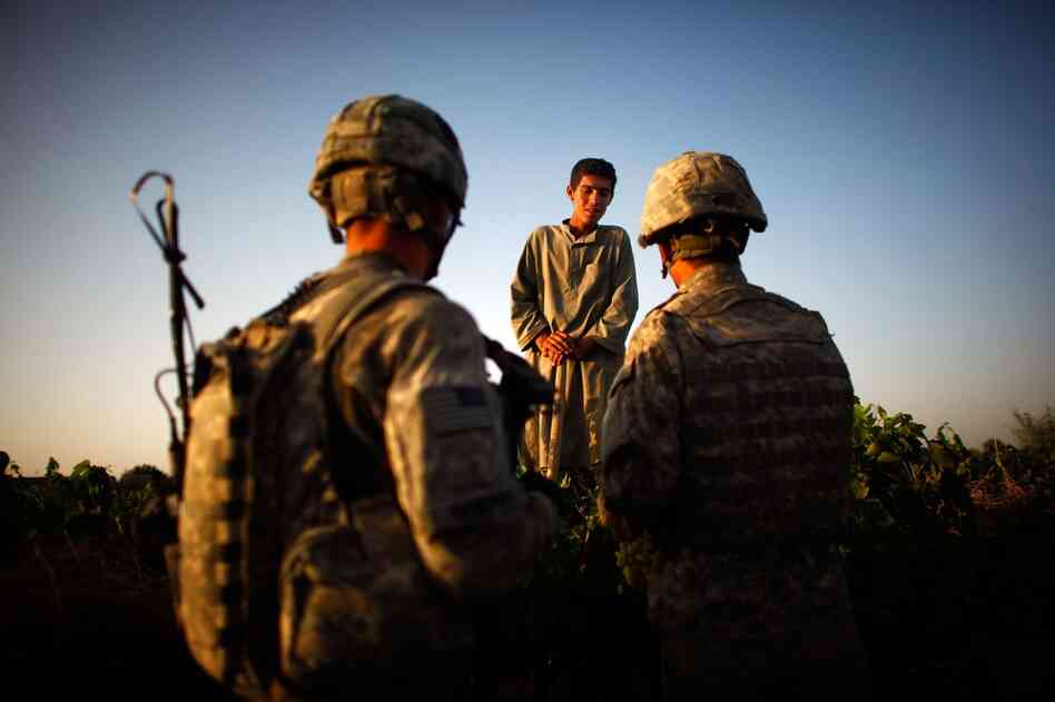 Soldiers with Bravo Company talk to a boy contracted to work in the vineyards. The soldiers are constantly patrolling in an effort to communicate with locals about security in the area.