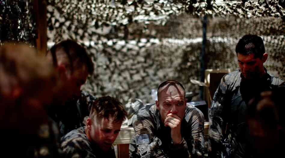 Pfc. Michael Stubbs (center) rests during a debriefing after the intense gun battle with the Taliban.