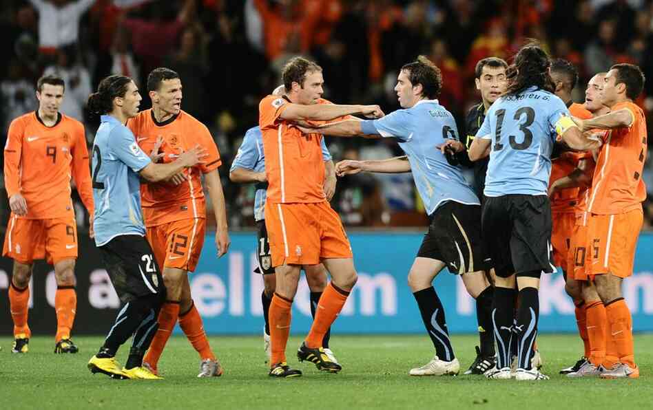 Members of the Uruguay and Netherlands teams, including Netherlands' Joris Mathijsen (center left) and Uruguay's Diego Godin (center right), scuffle at the end of the match. 
