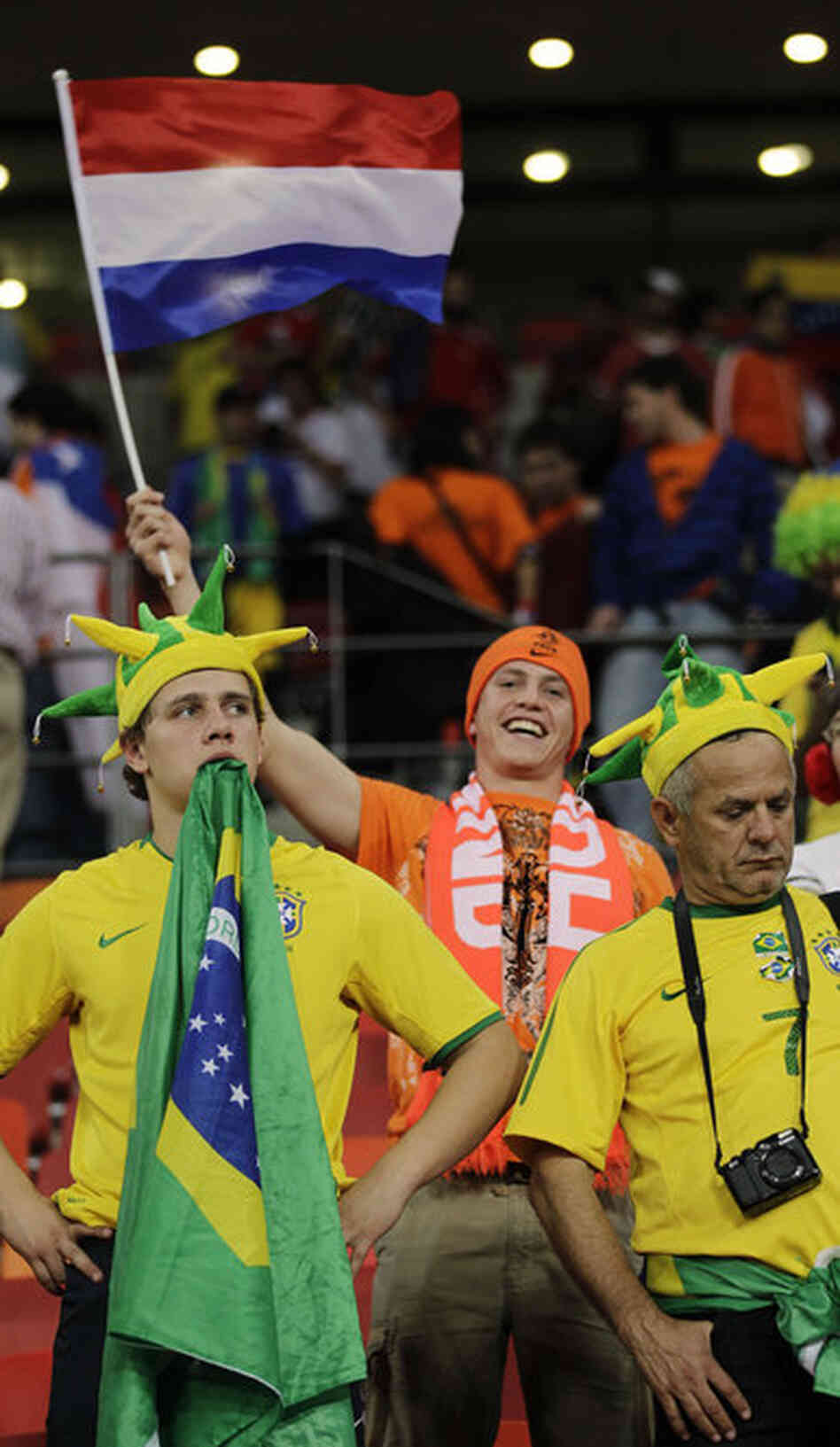 Brazil supporters react as a Netherlands fan celebrates following the quarterfinal match between the Netherlands and Brazil. Netherlands defeated Brazil 2-1. 