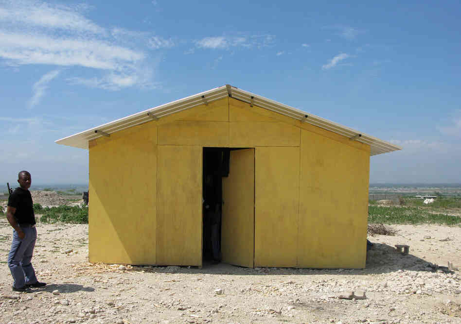 A guard stands outside a prototype "transitional" housing model at the resettlement camp in Corail-Cesselesse. World Vision along with several other aid agencies has developed these small dwellings, intended to house families of up to five people. 