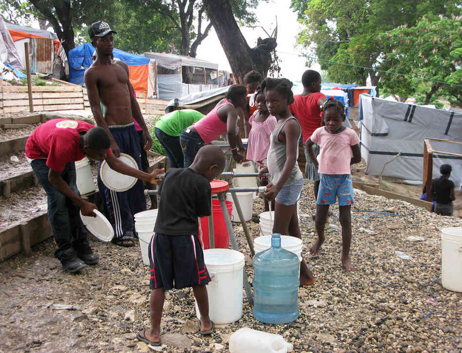 Late in the afternoon at Petionville Club camp, children gather to fill water jugs. The water is purified and safe to drink. 