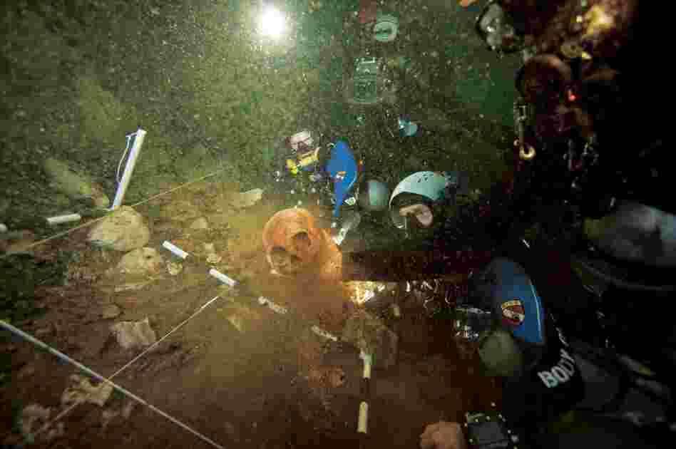 An archaeologist lifts a centuries-old Lucayan Indian skull from a  site 110 feet down into Sanctuary Blue Hole on Andros Island.