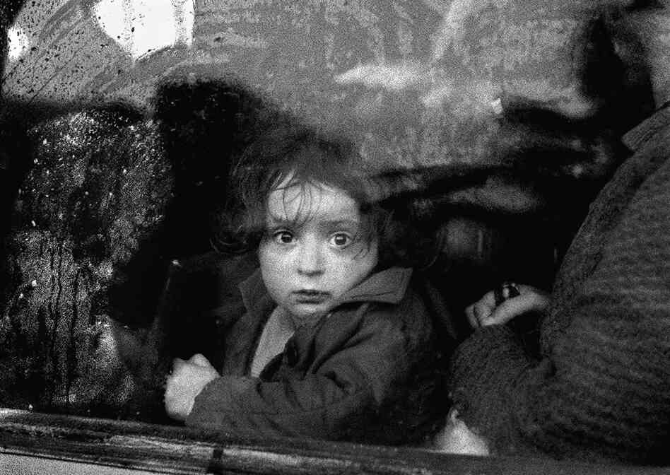 A young girl in Tirana, Albania, stares through a clouded bus window during a thunderstorm. 