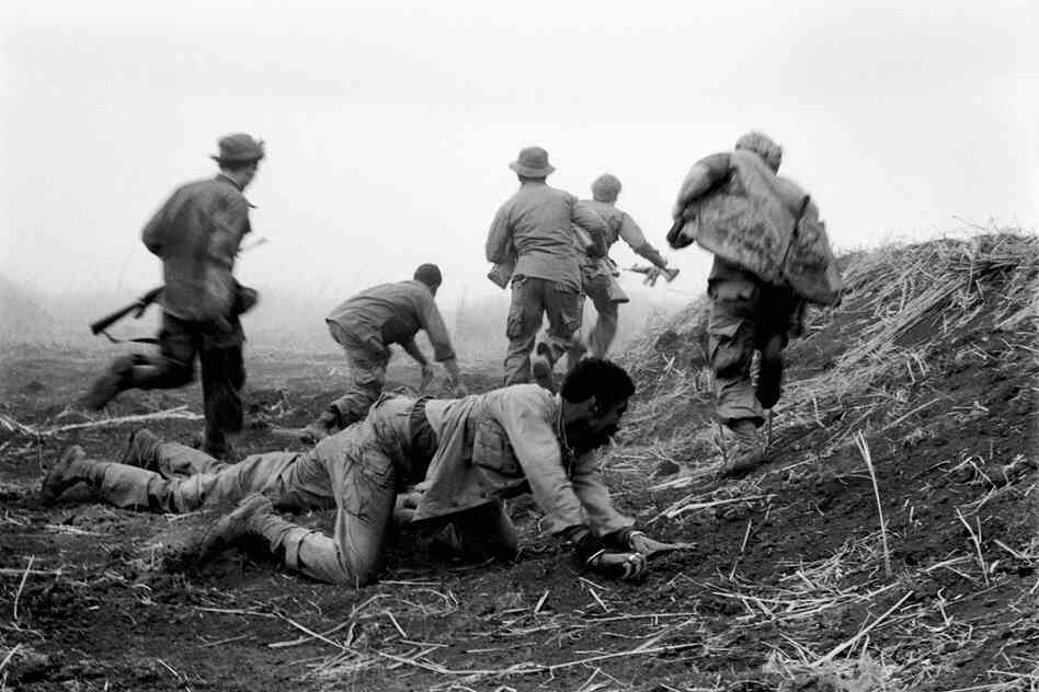 Soldiers scramble and duck artillery fire during the siege of Khe Sanh, Vietnam. 