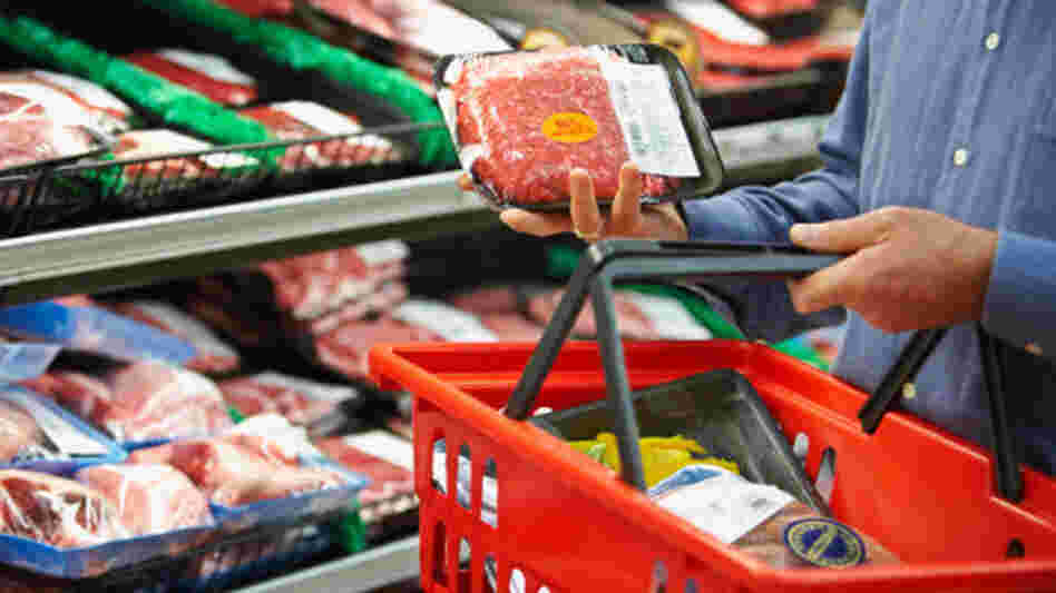 man inspects package of meat man inspects package of meat