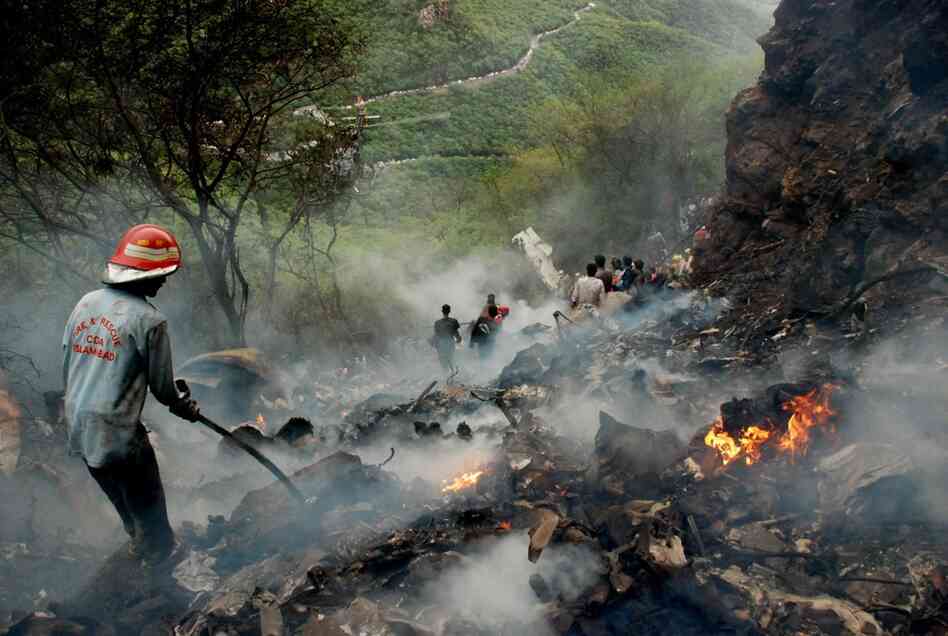 Pakistani rescue workers search the wreckage. Attempts to reach the site were initially hampered by muddy conditions. 