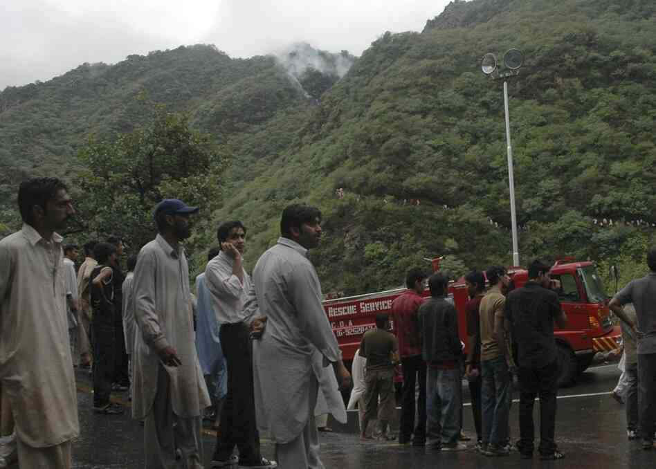 Local residents look toward the site of the plane crash. 