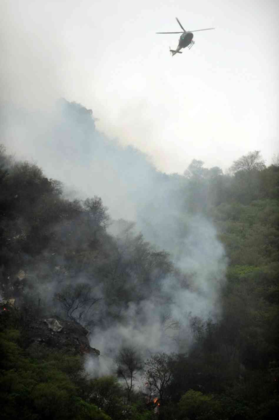 A Pakistani rescue helicopter flies above the crash site. 
