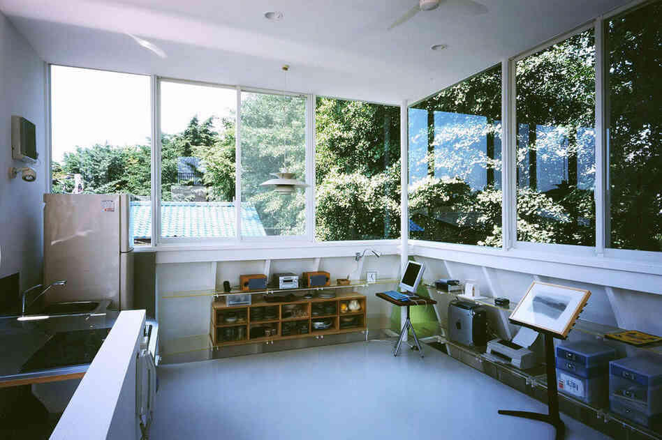 The sun-filled third floor of "Penguin House," with windows on all sides, contains the combined living room and kitchen.