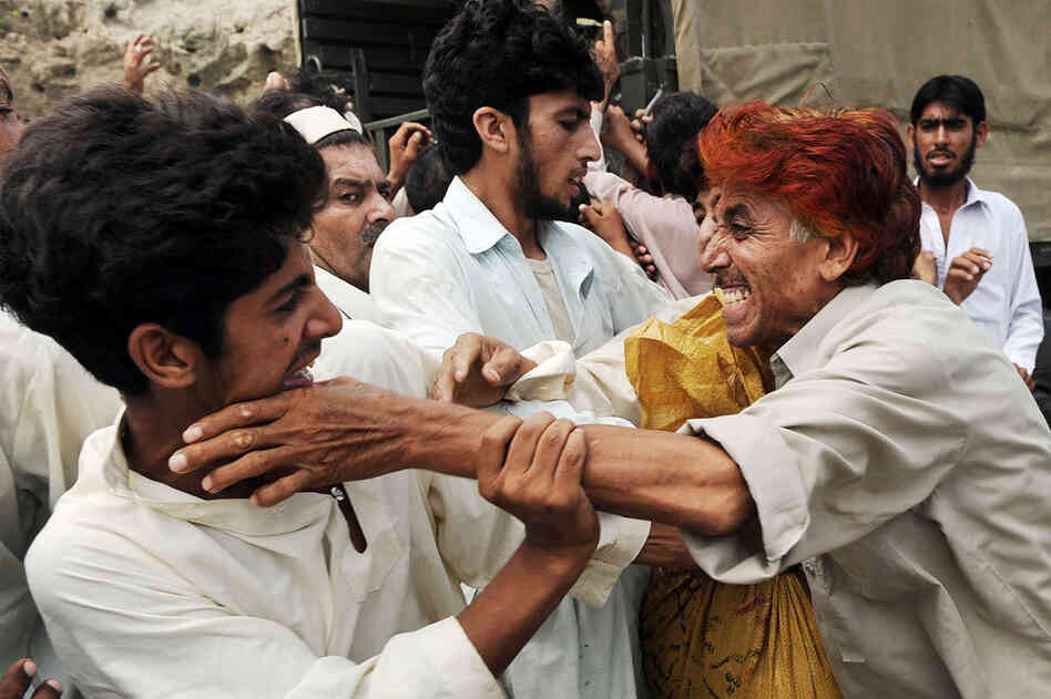 Flood victims fight for relief bags distributed by soldiers in Nowshera on Aug. 20. U.N. agencies stepped up calls for donors to deliver on their pledges for Pakistan to prevent what U.N. chief Ban Ki-moon called a "slow-motion tsunami" from wreaking further catastrophe.  
