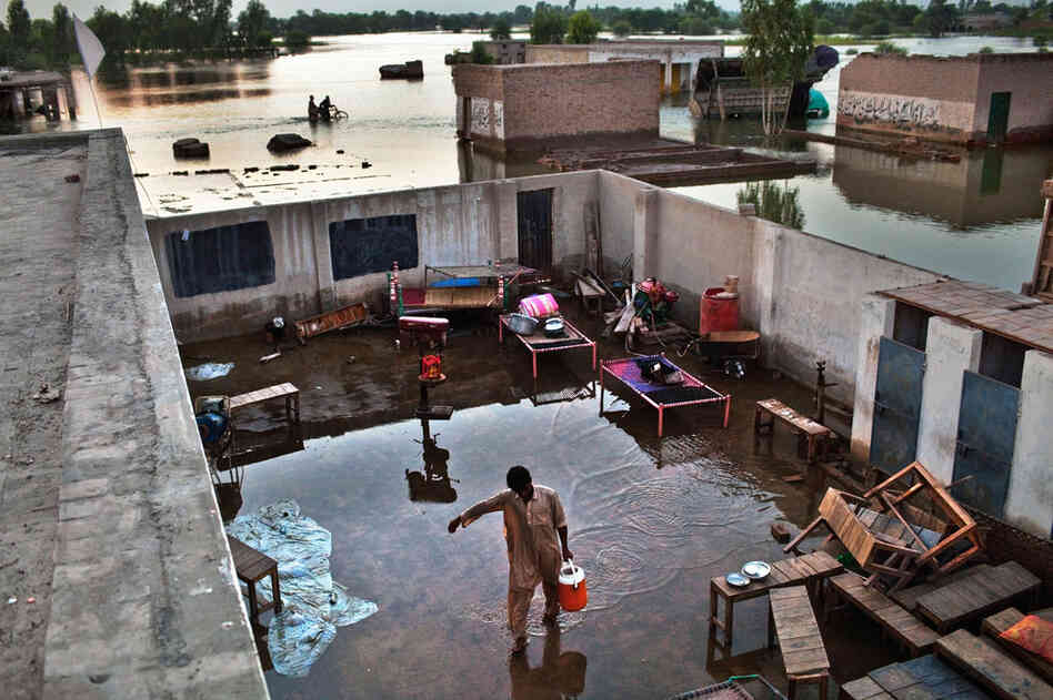 A boy carries water through a flooded yard in the village of Vasandawali in Punjab. The United Nations has appealed for $460 million to deal with the immediate aftermath of the floods, but has warned that billions will be required in the long term, with villages, businesses, crops and infrastructure wiped out. 