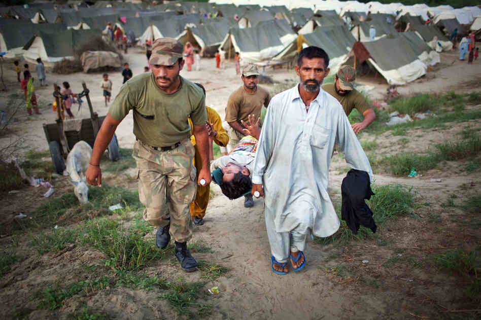 Suffering from high fever and spasms, Allah Detta is carried by soldiers as he is rushed to receive medical treatment in the Sultan Colony army flood relief camp. Military and aid organizations are struggling to cope with the scale of the disaster, in which more than 1,600 people have died and millions have been displaced. 