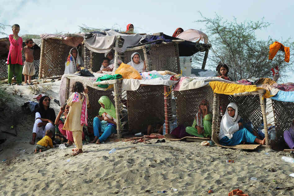 Pakistanis displaced by floods take shelter in temporary tents made with charpoys (bedsteads) near a makeshift camp in Baseera in Punjab province on Aug. 26. The United Nations warned that 800,000 people in desperate need of aid had been cut off by the deluge across the country and appealed for more helicopters to deliver supplies to those people reachable only by air. 