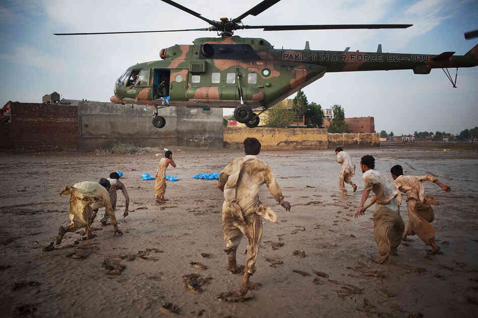 Residents grab water bottles dropped from a Pakistani air force helicopter Aug. 2 in Nowshera, where thousands were affected by the floods. 