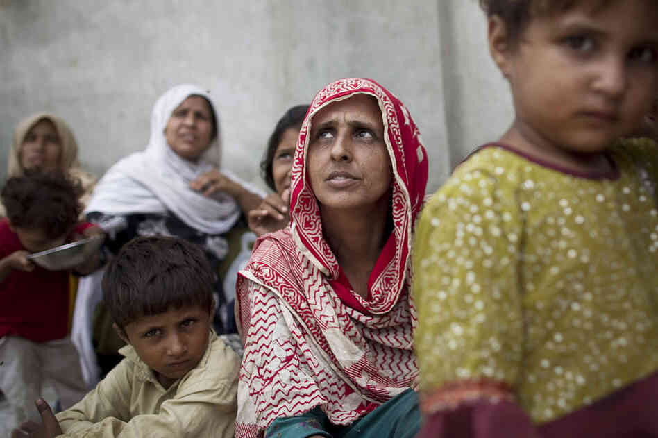 Bibi Gul (center) sits with her family in a school transformed into a camp for displaced people on the outskirts of Nowshera. The monsoon swallowed up Gul's house and two of her children. With no news of her son and daughter days later, she is distraught. 