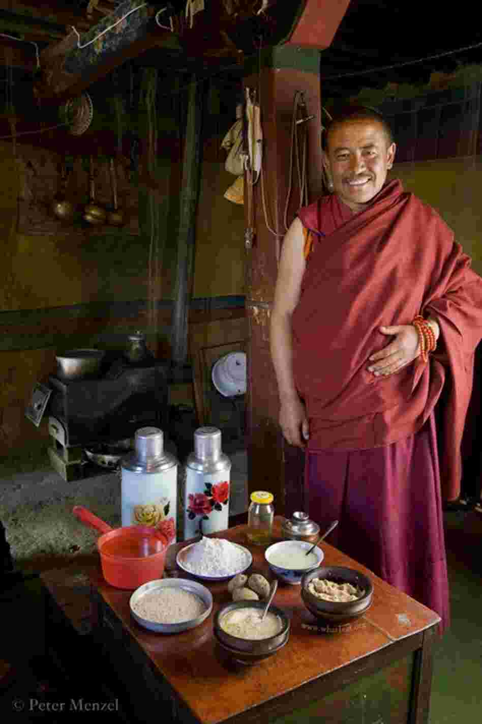 The head monk at his partially rebuilt monastery with a typical day's worth of food in the Tibetan Plateau. He is 45, 5 foot 5, 158 pounds, and his day of calories in June was 4,900 kcals. His food: butter tea, barley flour cake, dried cheese curds, noodle soup with potato, etc.