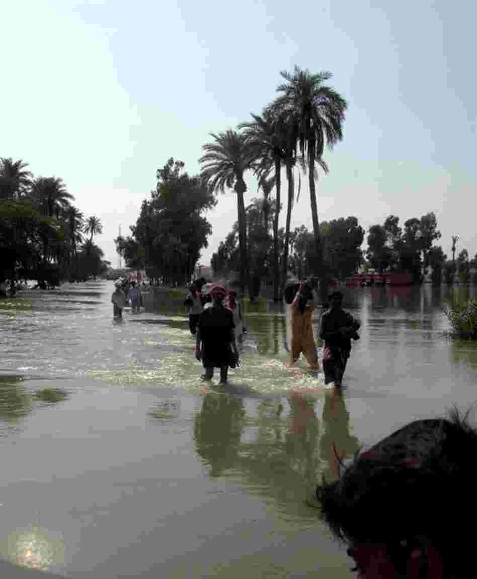 Survivors wade through flood waters washing over the main road connecting the southern Punjab cities of Dera Ghazi Khan and Muzaffargarh. Residents in the village of Bahawal Nala say that some 25 to 30 people have drowned trying to cross the main road that is now five feet under water.