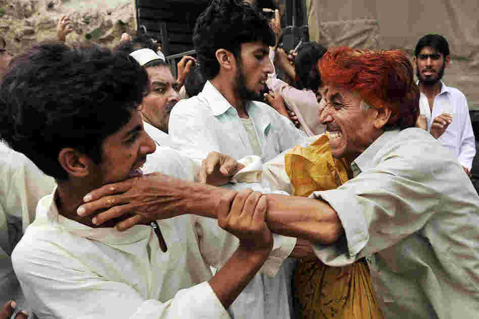 Flood victims fight for relief bags distributed by soldiers in Nowshera on Aug. 20. U.N. agencies stepped up calls for donors to deliver on their pledges for Pakistan to prevent what U.N. chief Ban Ki-moon called a "slow-motion tsunami" from wreaking further catastrophe.  