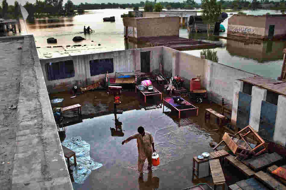 A boy carries water through a flooded yard in the village of Vasandawali in Punjab. The United Nations has appealed for $460 million to deal with the immediate aftermath of the floods, but has warned that billions will be required in the long term, with villages, businesses, crops and infrastructure wiped out. 
