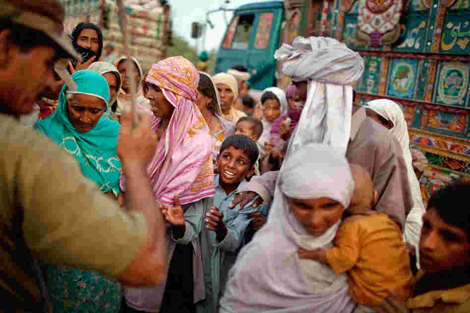 A boy and other displaced villagers plead for relief rations as a soldier waves a stick in an attempt to maintain order in the Sultan Colony army flood relief camp on Aug. 25. Pakistan's agricultural heartland has been devastated, with rice, corn and wheat crops destroyed by floods. 