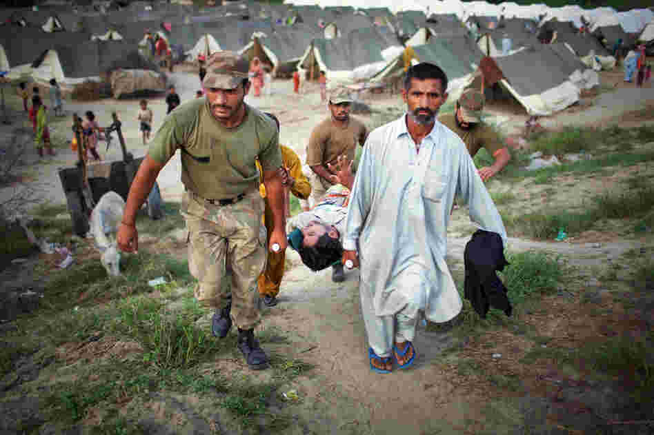 Suffering from high fever and spasms, Allah Detta is carried by soldiers as he is rushed to receive medical treatment in the Sultan Colony army flood relief camp. Military and aid organizations are struggling to cope with the scale of the disaster, in which more than 1,600 people have died and millions have been displaced. 