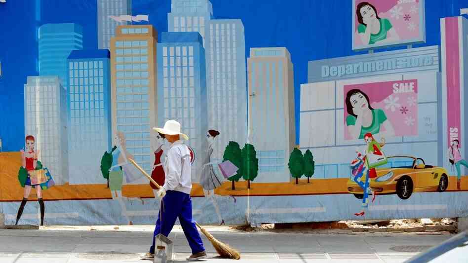 A worker in Beijing in front of a mural. A worker in Beijing in front of a mural.