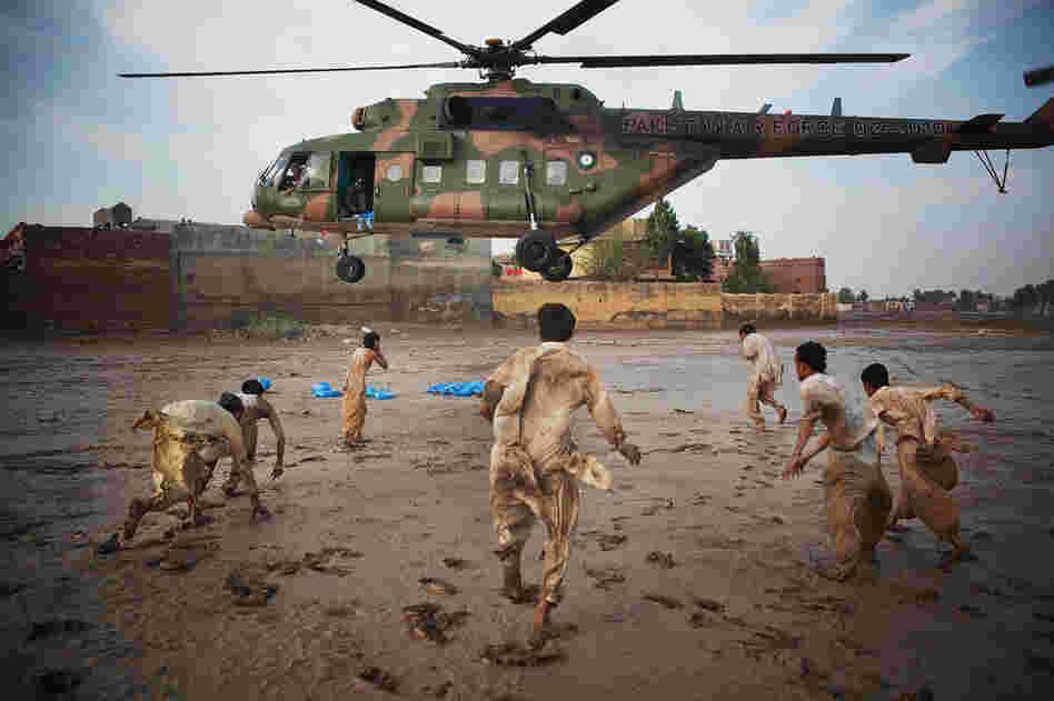Residents grab water bottles dropped from a Pakistani air force helicopter Aug. 2 in Nowshera, where thousands were affected by the floods. 
