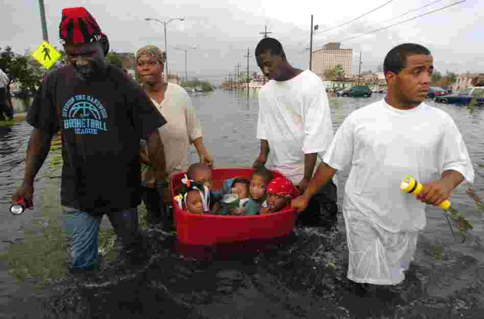 The flooding of New Orleans was well underway by Monday afternoon as John Rainey, John Rainey, Jr. and Courtney Davis helped Terry Fox tug a tub full of children to higher ground on South Broad Street on Aug. 29, 2005. 