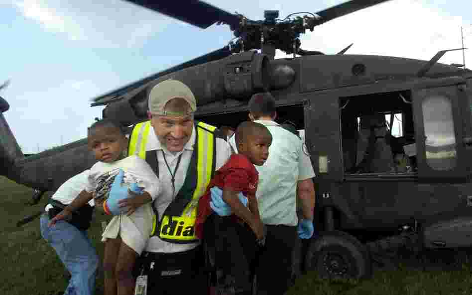 The Interstate 10 Causeway Blvd cloverleaf became an evacuation staging area on Aug. 28, 2005. Amid the sea of organized chaos, Jeff Thibodaux with Acadian Ambulance rushed two small children from a Blackhawk helicopter after being evacuated from the Louisiana Superdome. 