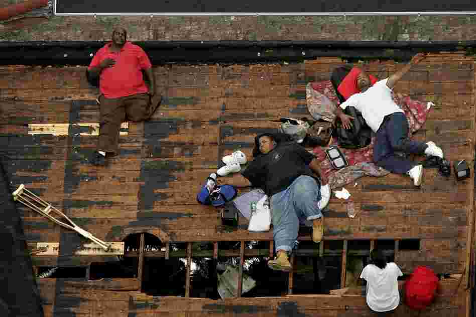 Residents, including a man with only one leg, wait on a rooftop to be rescued from the floodwaters of New Orleans on Sept. 1, 2005, as officials evacuate the city after Hurricane Katrina. 