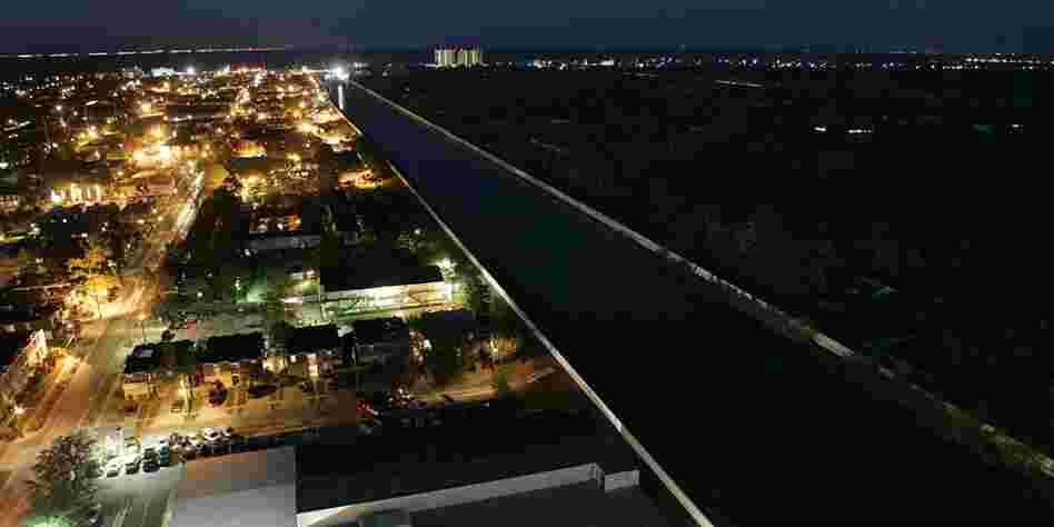 The lights of Metairie seem even brighter, when just across the 17th Street Canal New Orleans is a sea of darkness, Sept. 18. 2005. 
