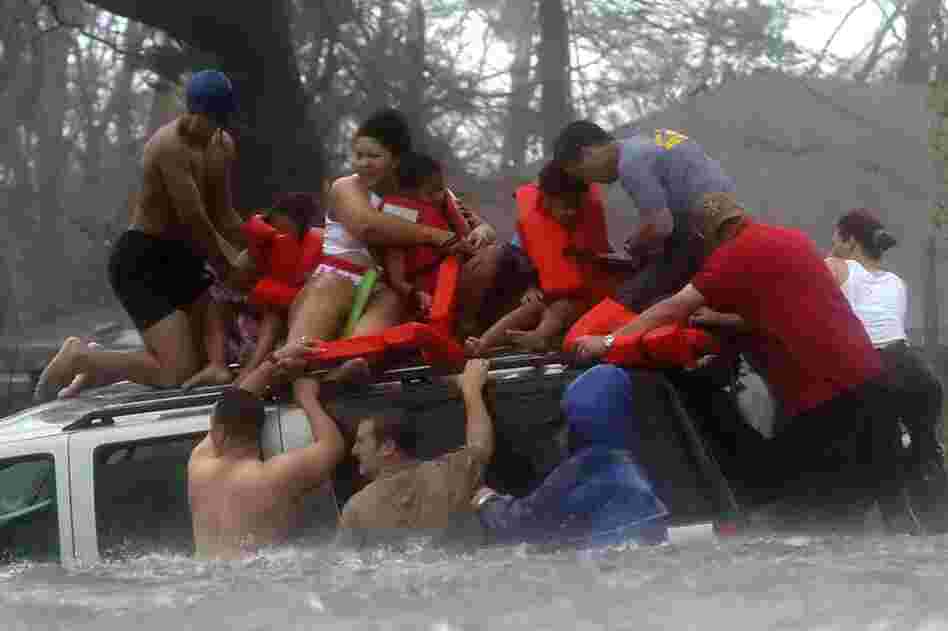 Bay St. Louis Emergency Management Agency volunteer crews rescue the Taylor family from the roof of their Suburban, which became trapped on U.S. 90 due to flooding during Hurricane Katrina on Aug. 28, 2005. 