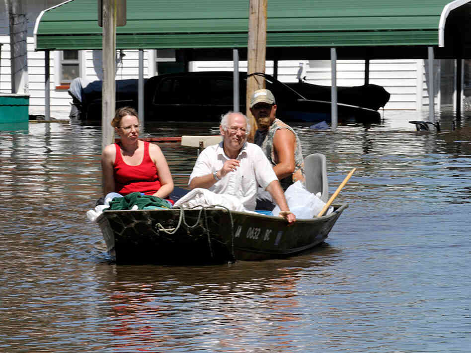 Residents boat down the street outside their home on floodwaters from the South Skunk River. Residents boat down the street outside their home on floodwaters from the South Skunk River.