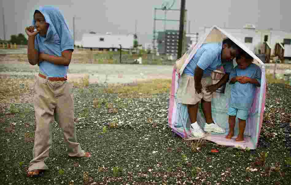 Children play in the rain at the FEMA Diamond travel trailer park May 22, 2008, in Port Sulphur, La.