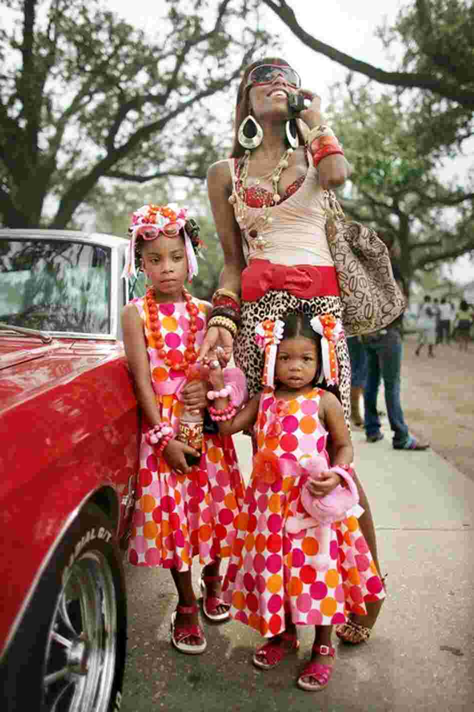 Angel Price talks on her mobile phone with her daughters Brielle, 8, and Cache, 2, as the Original Big 7 Social Aid and Pleasure Club holds a traditional second line parade May 14, 2006, in New Orleans' 7th Ward. It was first time the parade had been held since Hurricane Katrina.
