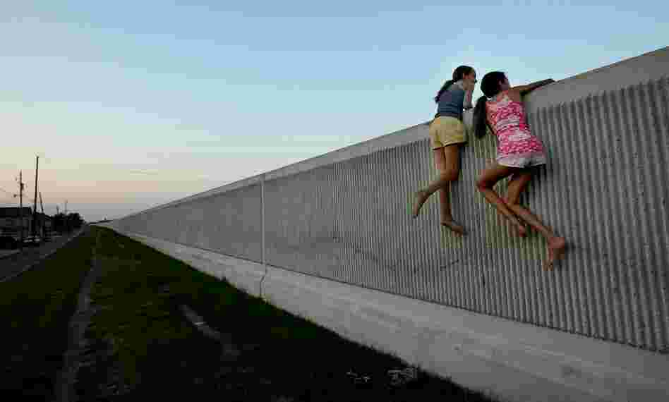 Isabella Lander (left) and Arabella Christiansen climb on the 17th Street Canal levee May 29, 2008, in Metairie, La. Despite $22 million in repairs, the 17th Street Canal levee, which broke during Hurricane Katrina, is leaking. Experts fear the levee could fail again in another large storm.