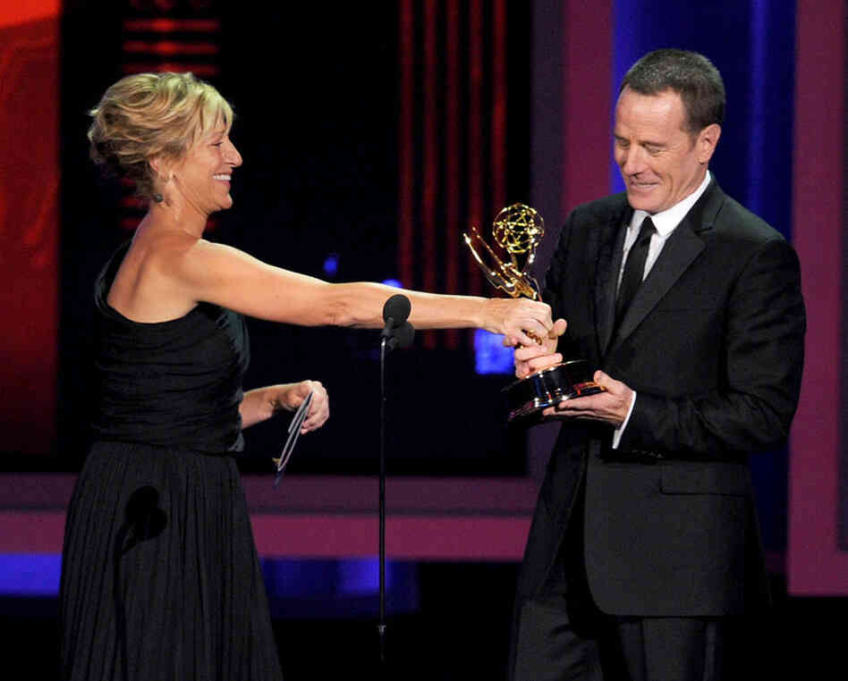 Actor Bryan Cranston, right, accepts the Outstanding Lead Actor in a Drama Series award for Breaking Bad from actress Edie Falco onstage at the Emmy Awards.  