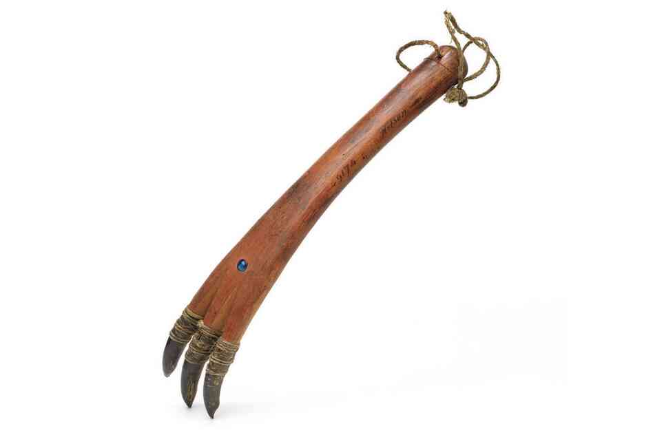 Yupik ice scratcher. Hunters stalked seals as they slept or sunned themselves on the sea ice. If the animals became startled, the hunter would scratch the ice with this tool, which imitated the sound of a seal digging its hole and would lull the animal back to sleep. The blue bead represents the passageway between the human and animal worlds.