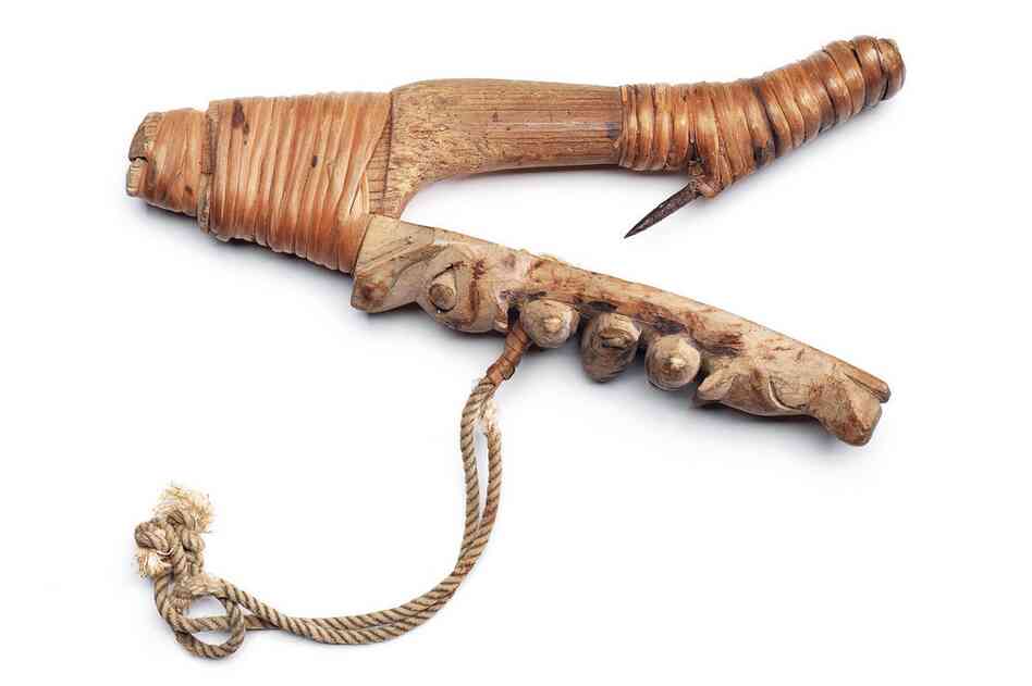 Sugpiaq halibut hook. Halibut was a staple food and was caught with these V-shaped wooden hooks, which were floated just above the seafloor by an inflated stomach buoy. Spirit figures were carved on the hook to attract the fish.