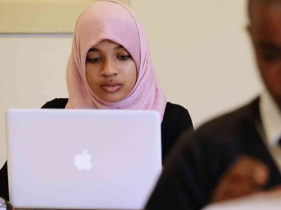A young Muslim woman uses her computer. A young Muslim woman uses her computer.